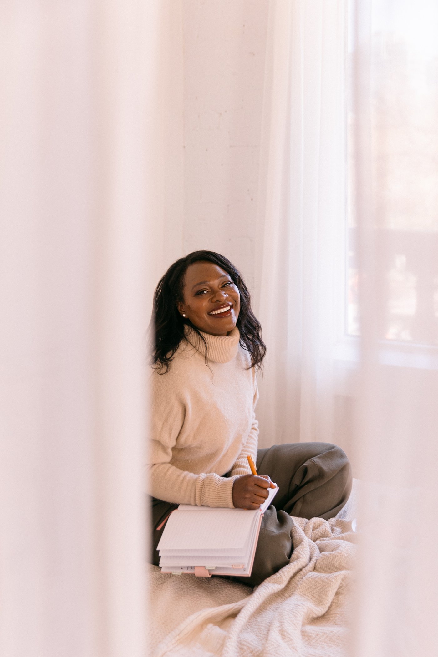 Rozella laughing while journaling by a sunlit window